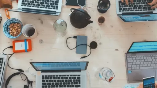 A bunch of laptops on a table from above